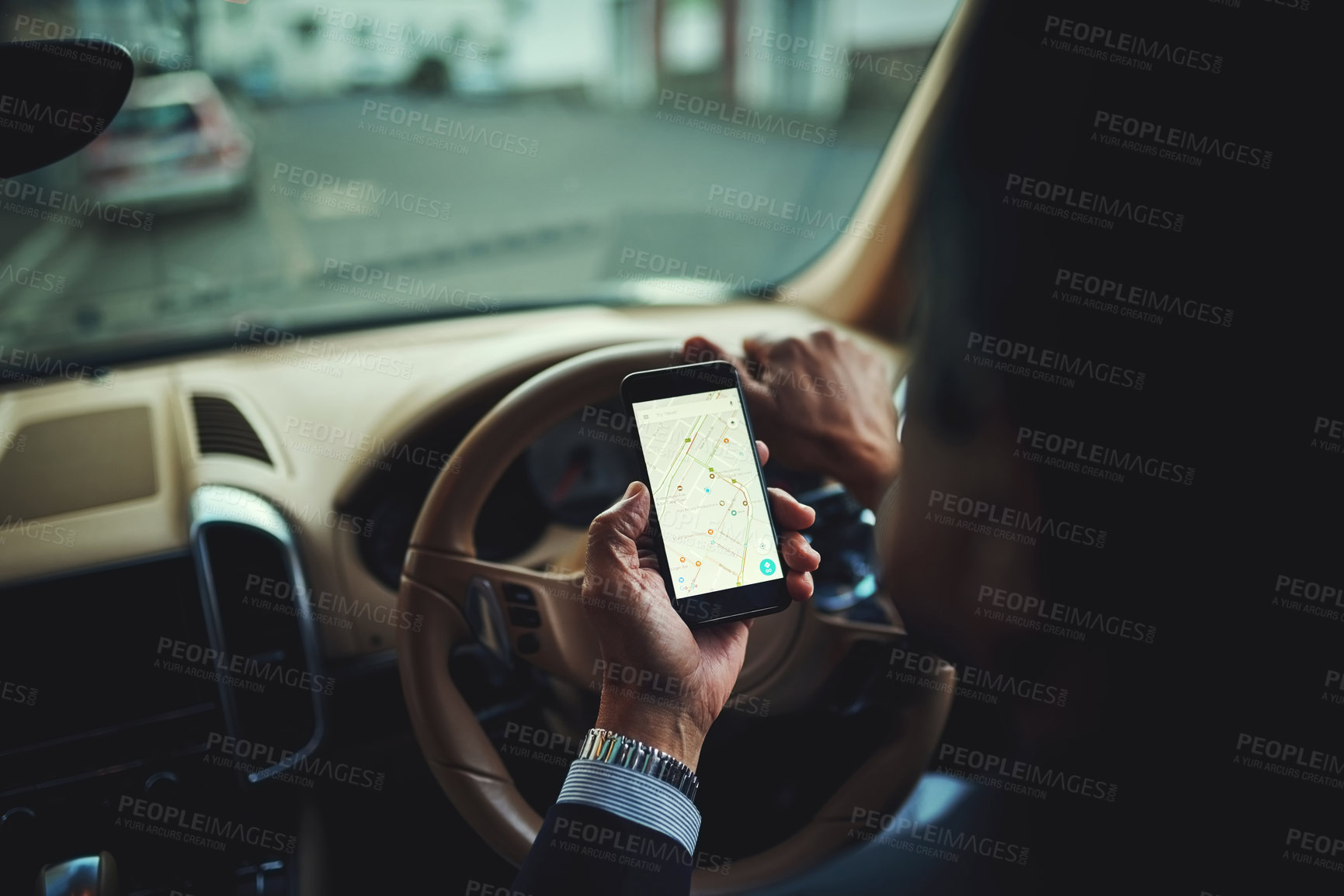 Buy stock photo Cropped shot of a businessman using his phone’s gps while driving a car