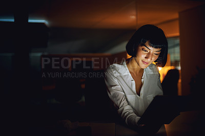 Buy stock photo Shot of a young businesswoman using a digital tablet during a late night at work