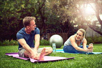 Buy stock photo Shot of a young couple exercising together outdoors