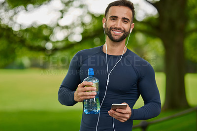 Buy stock photo Water, outdoor and portrait of man with earphones for listening to music, podcast or radio in nature. Happy, hydration and male athlete with audio tech for streaming running playlist on phone at park