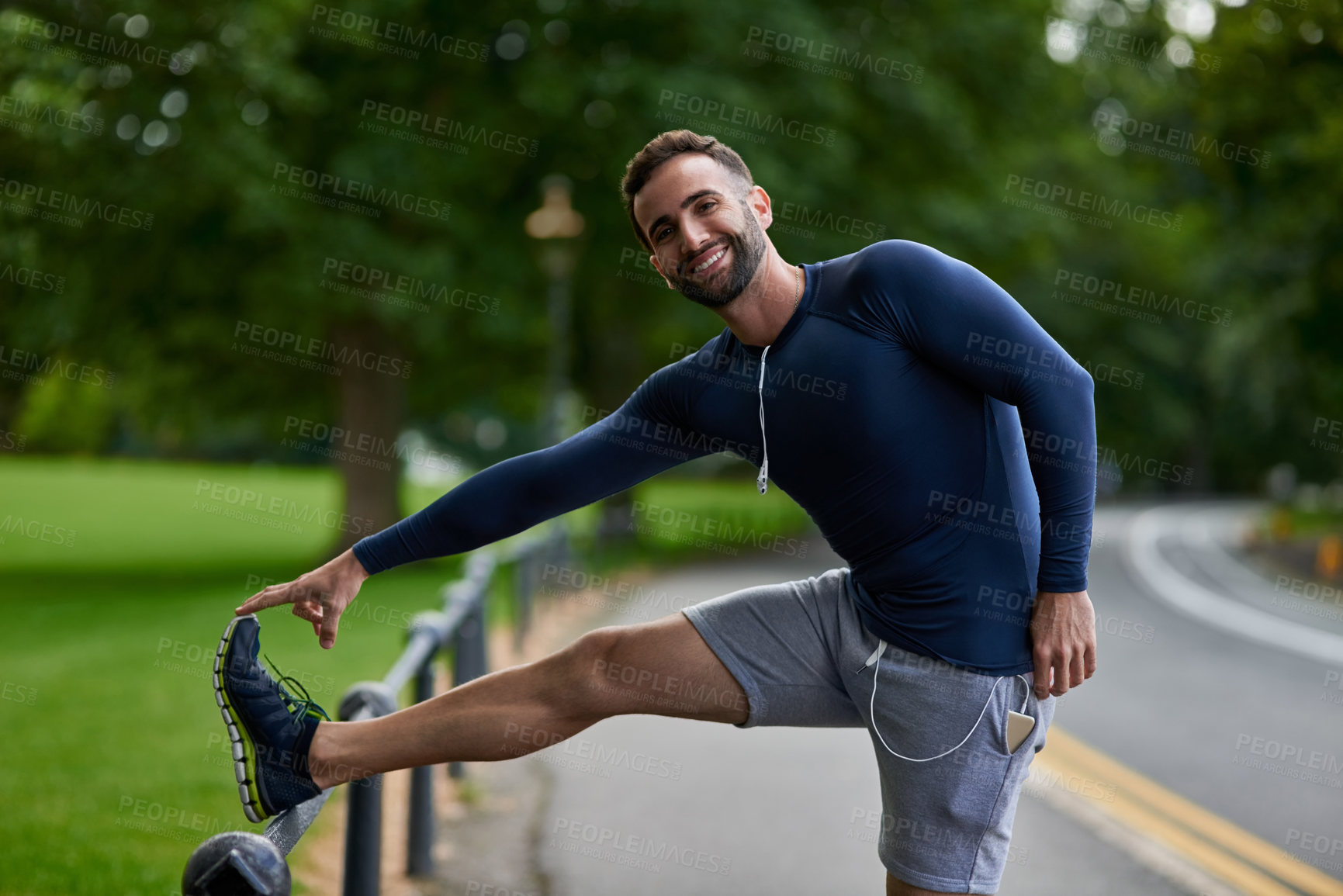 Buy stock photo Cropped portrait of a handsome young male runner warming up before his workout