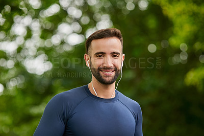 Buy stock photo Cropped portrait of a handsome young male runner listening to music during his workout