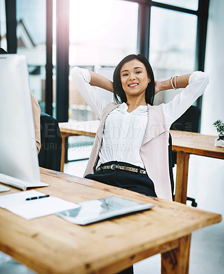 Buy stock photo Cropped portrait of an attractive young female designer sitting with her hands behind her head at her desk