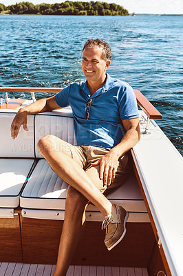 Buy stock photo Shot of a mature man enjoying a relaxing boat ride