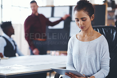 Buy stock photo Shot of a young businesswoman using a digital tablet during a meeting in an office