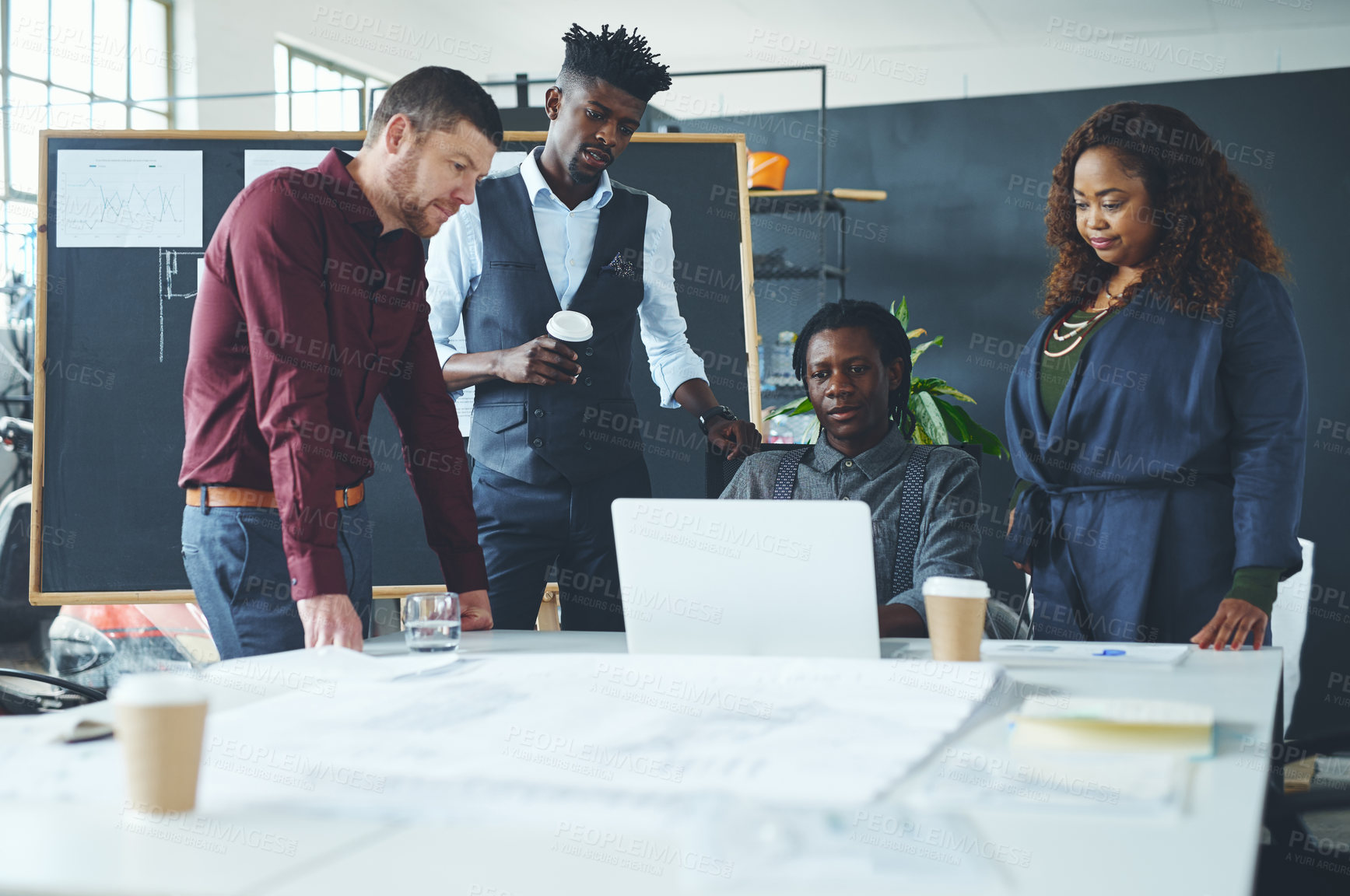 Buy stock photo Shot of a group of coworkers discussing something on a laptop during a meeting