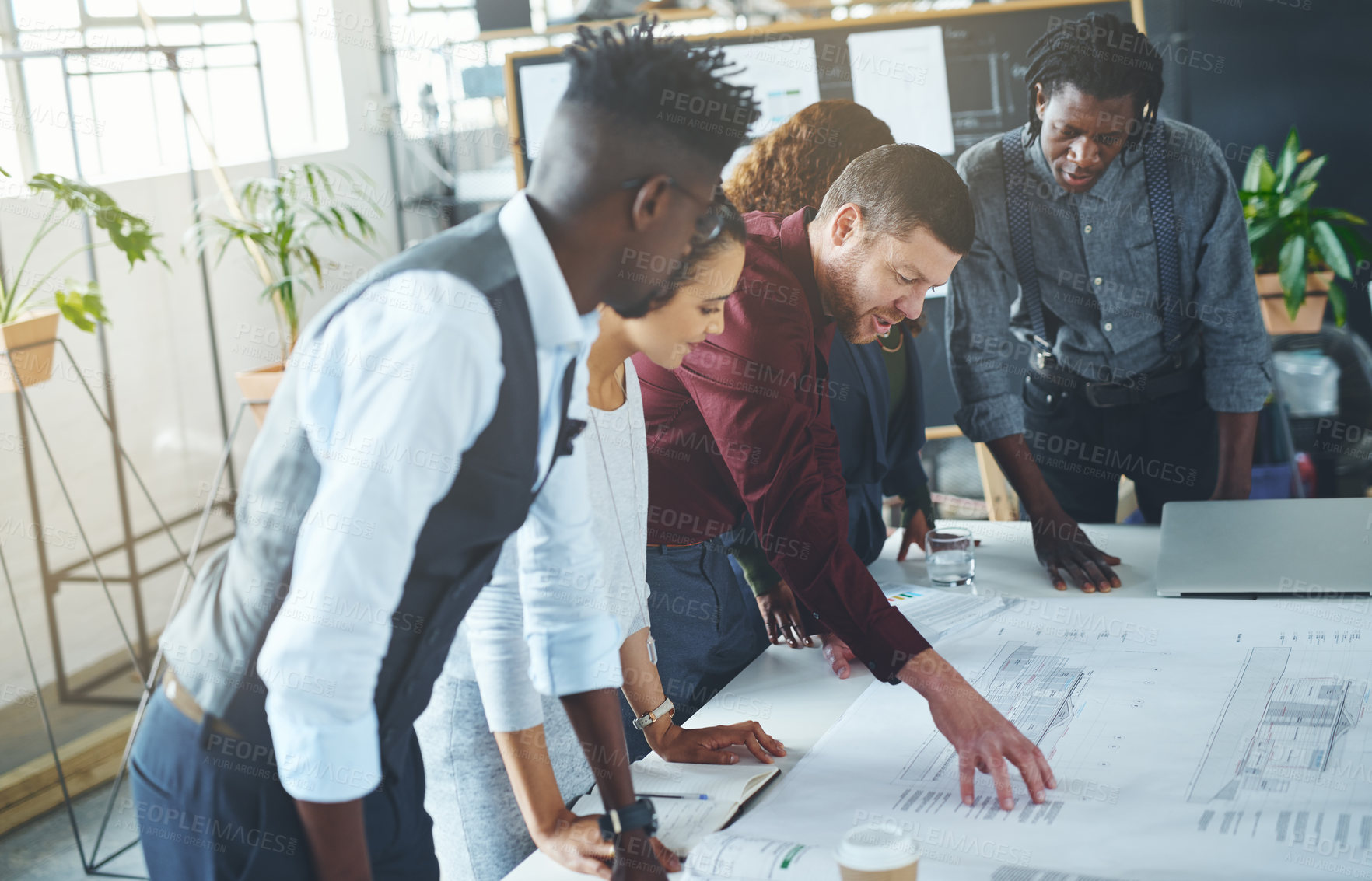 Buy stock photo Cropped shot of a team of professionals working on blueprints in an office