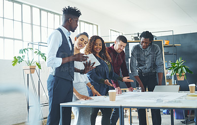 Buy stock photo Cropped shot of a team of professionals working on blueprints in an office