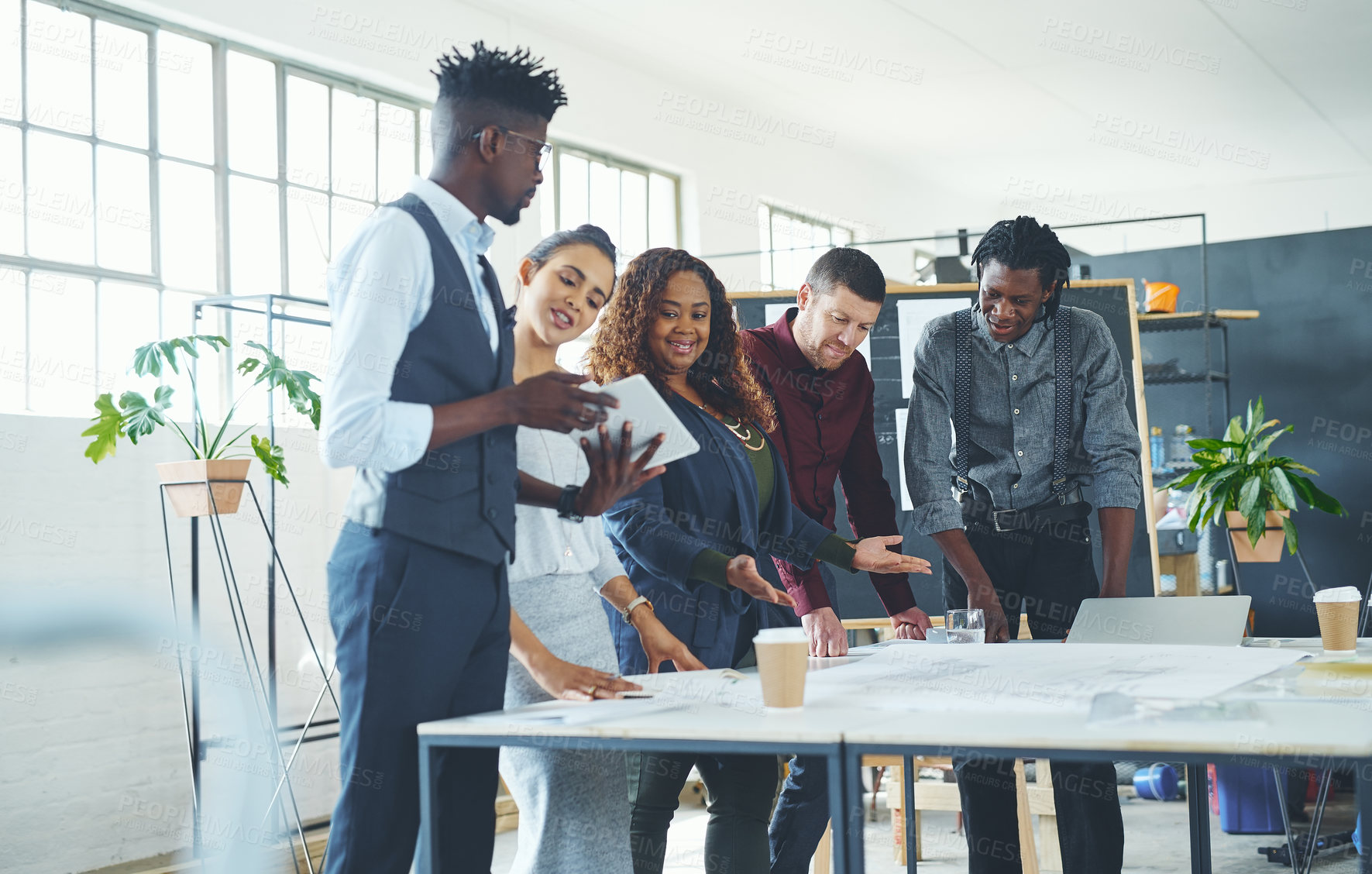 Buy stock photo Cropped shot of a team of professionals working on blueprints in an office