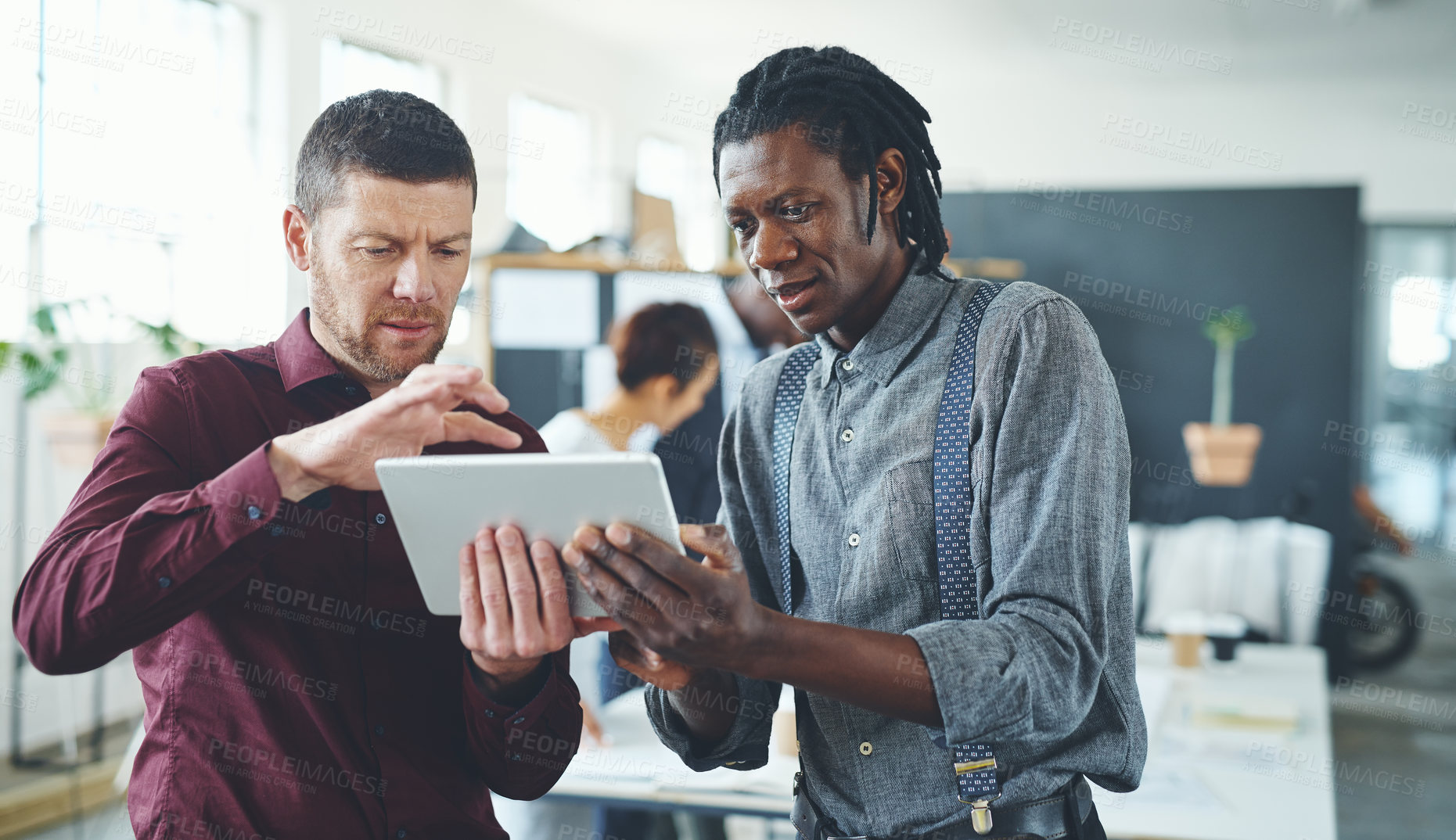 Buy stock photo Cropped shot of two businesspeople working together on a digital tablet in an office