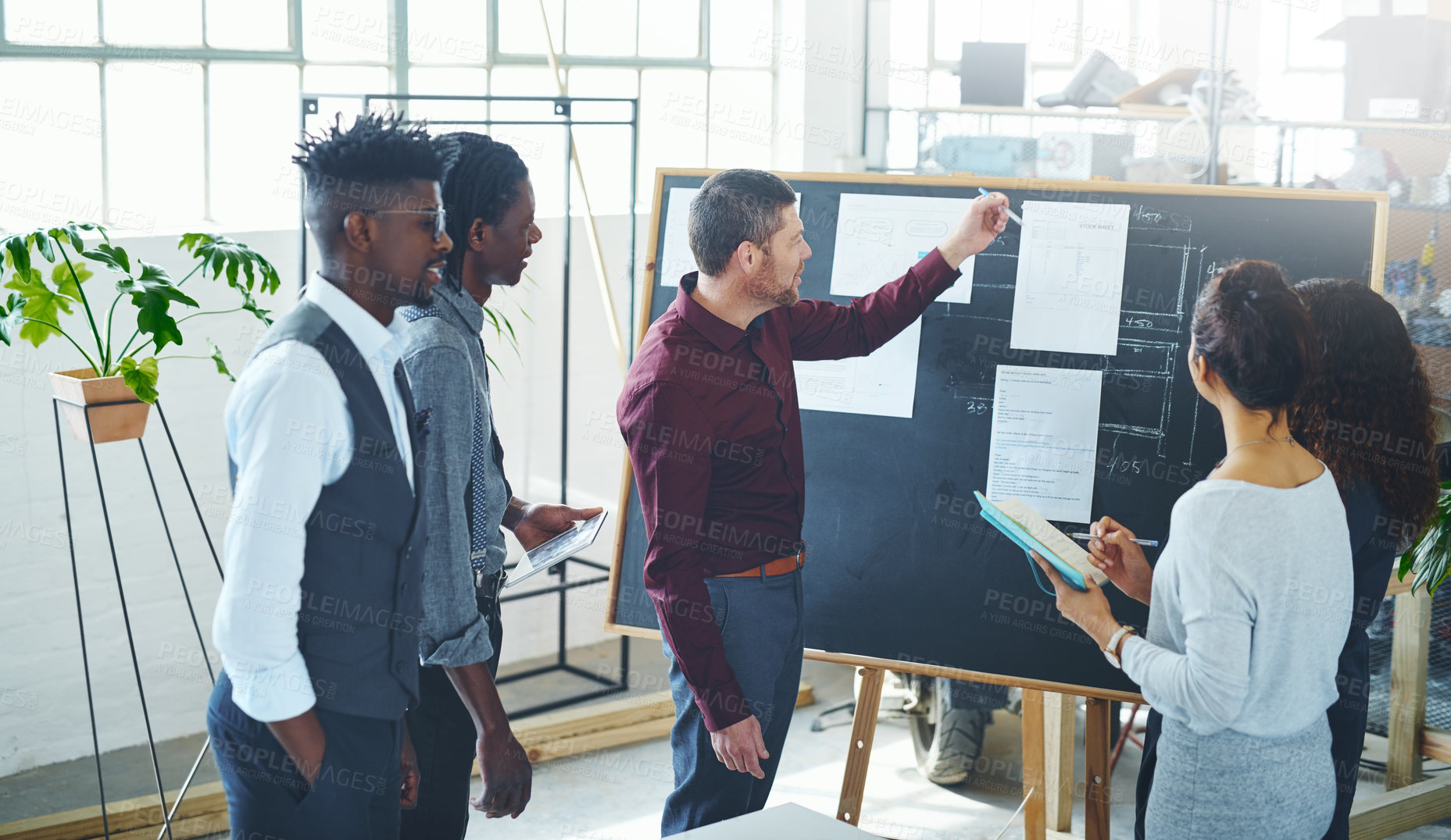 Buy stock photo Shot of a group of businesspeople discussing statistics