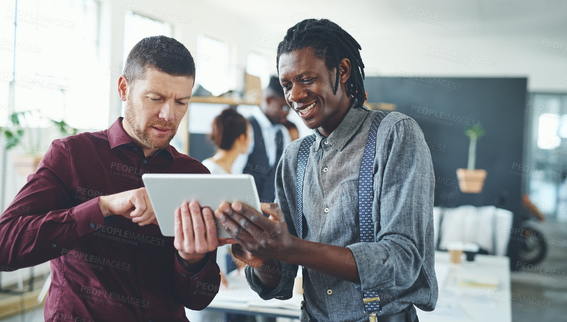 Buy stock photo Cropped shot of two businesspeople working together on a digital tablet in an office