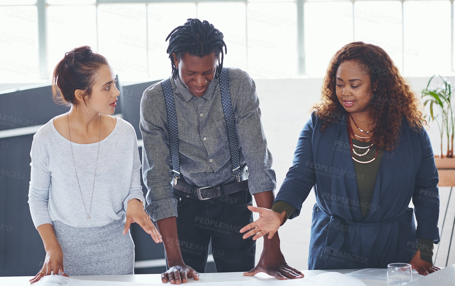 Buy stock photo Cropped shot of a team of professionals working on blueprints in an office