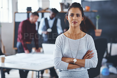 Buy stock photo Cropped portrait of an attractive young businesswoman standing with her arms folded with her colleagues in the background