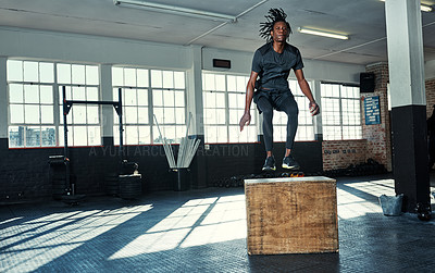 Buy stock photo Shot of a young man doing jumping exercises on a wooden block in a gym