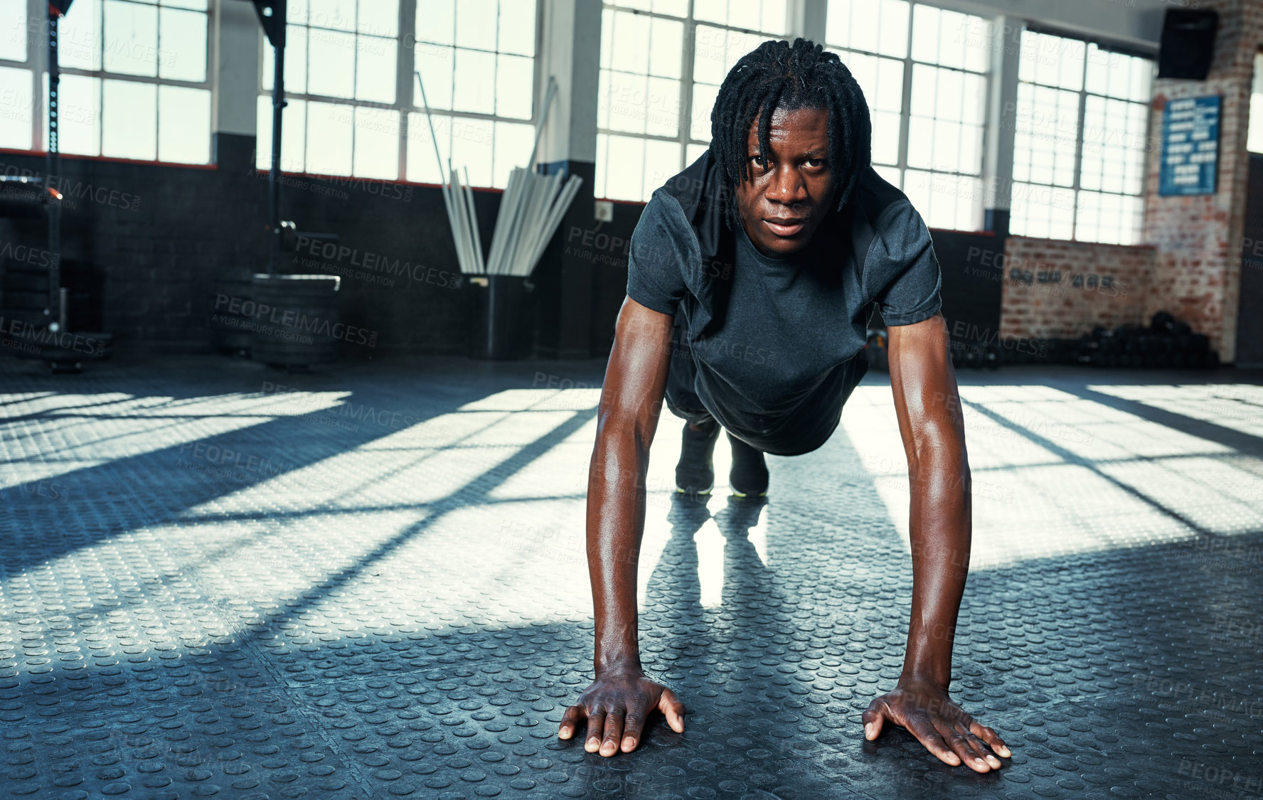 Buy stock photo Shot of a young man doing push ups in a gym