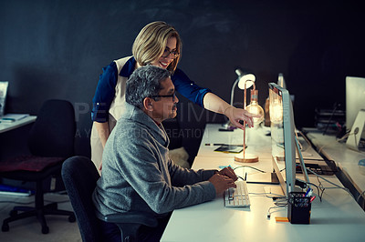 Buy stock photo Shot of two businesspeople working late in an office