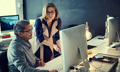 Buy stock photo Shot of two businesspeople working late in an office