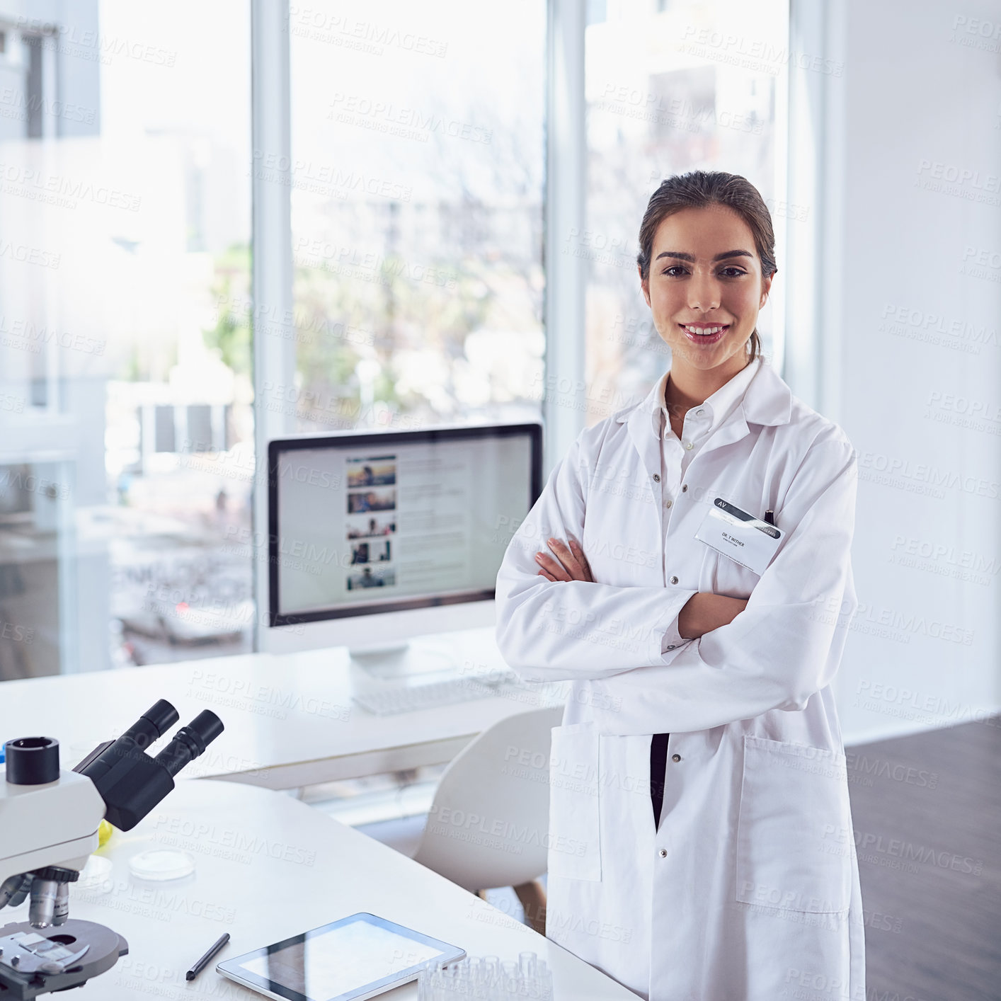 Buy stock photo Portrait of a confident young female scientist standing with arms folded while looking at the camera in a laboratory