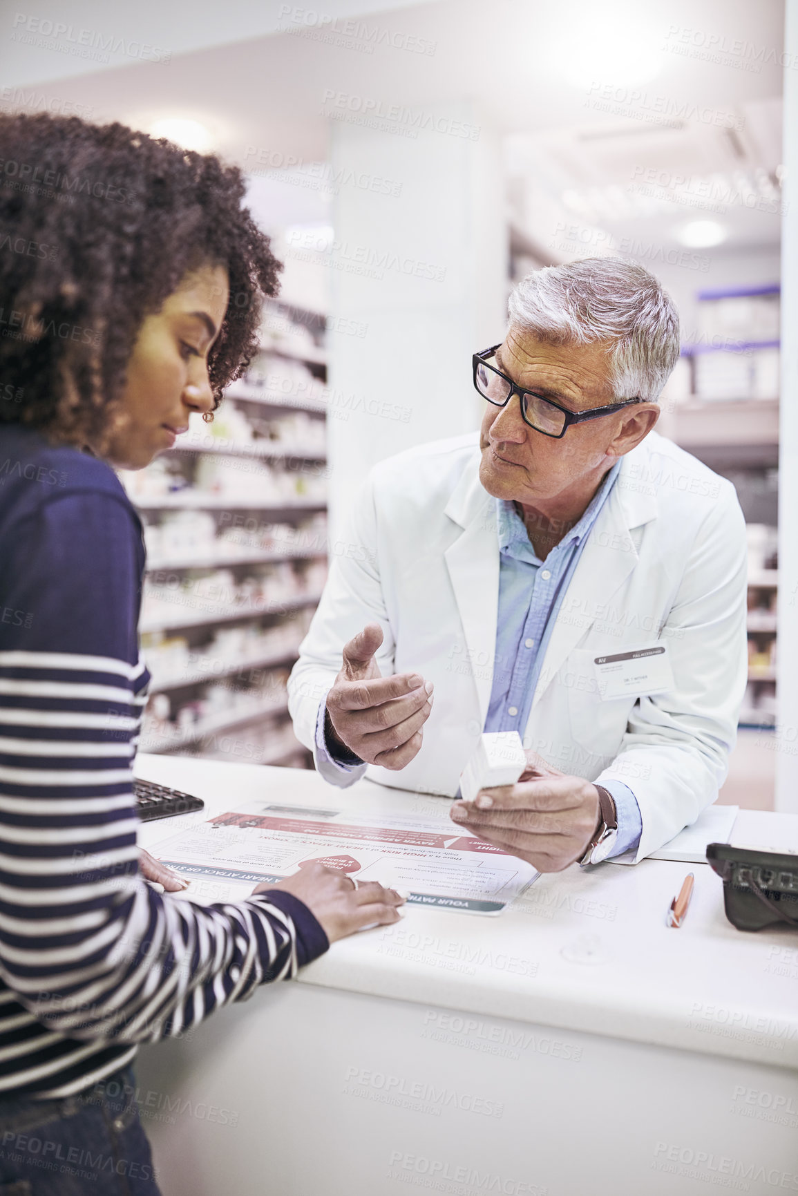 Buy stock photo Shot of a dedicated mature male pharmacist giving a customer prescription meds over the counter