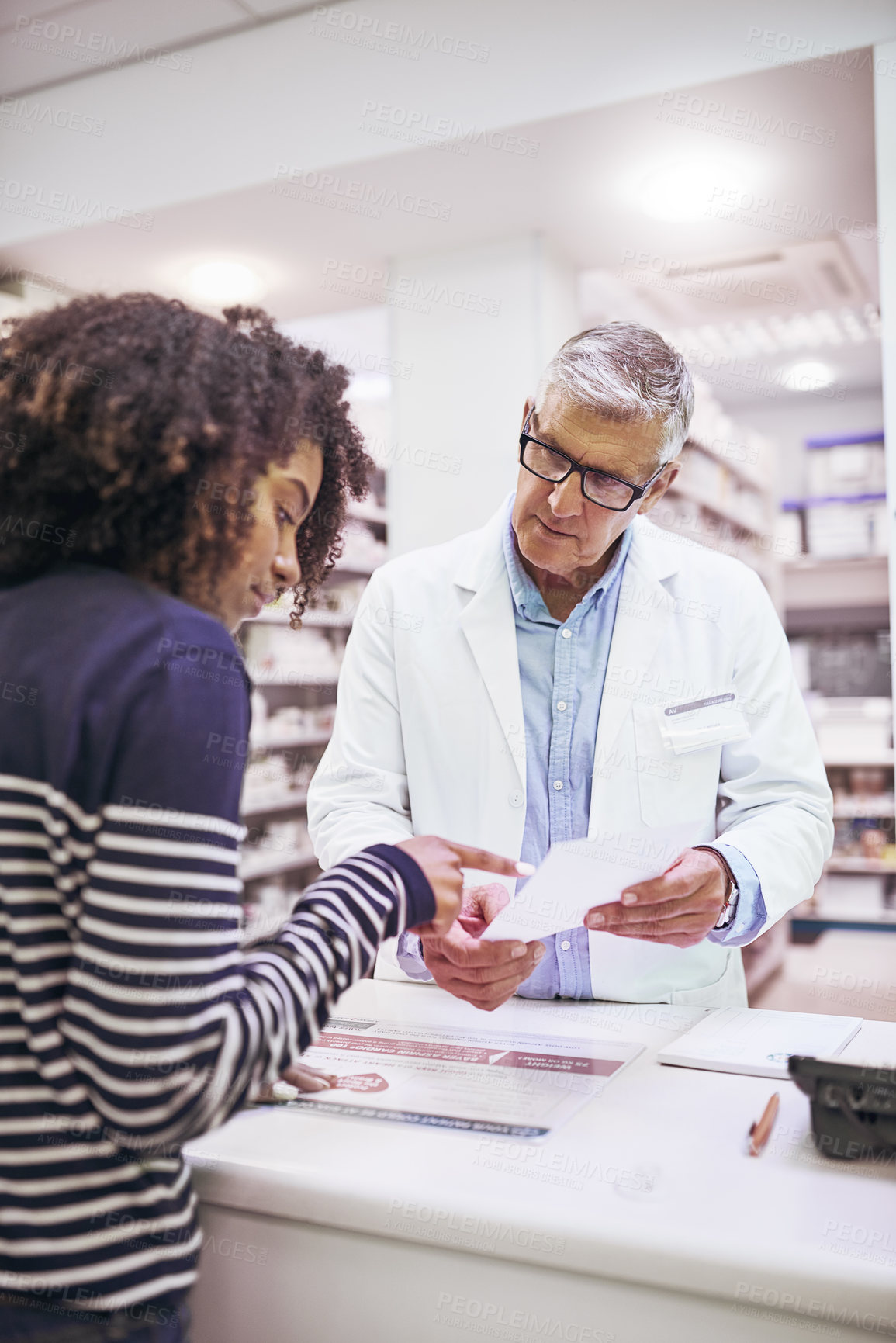 Buy stock photo Shot of a dedicated mature male pharmacist giving a customer prescription meds over the counter