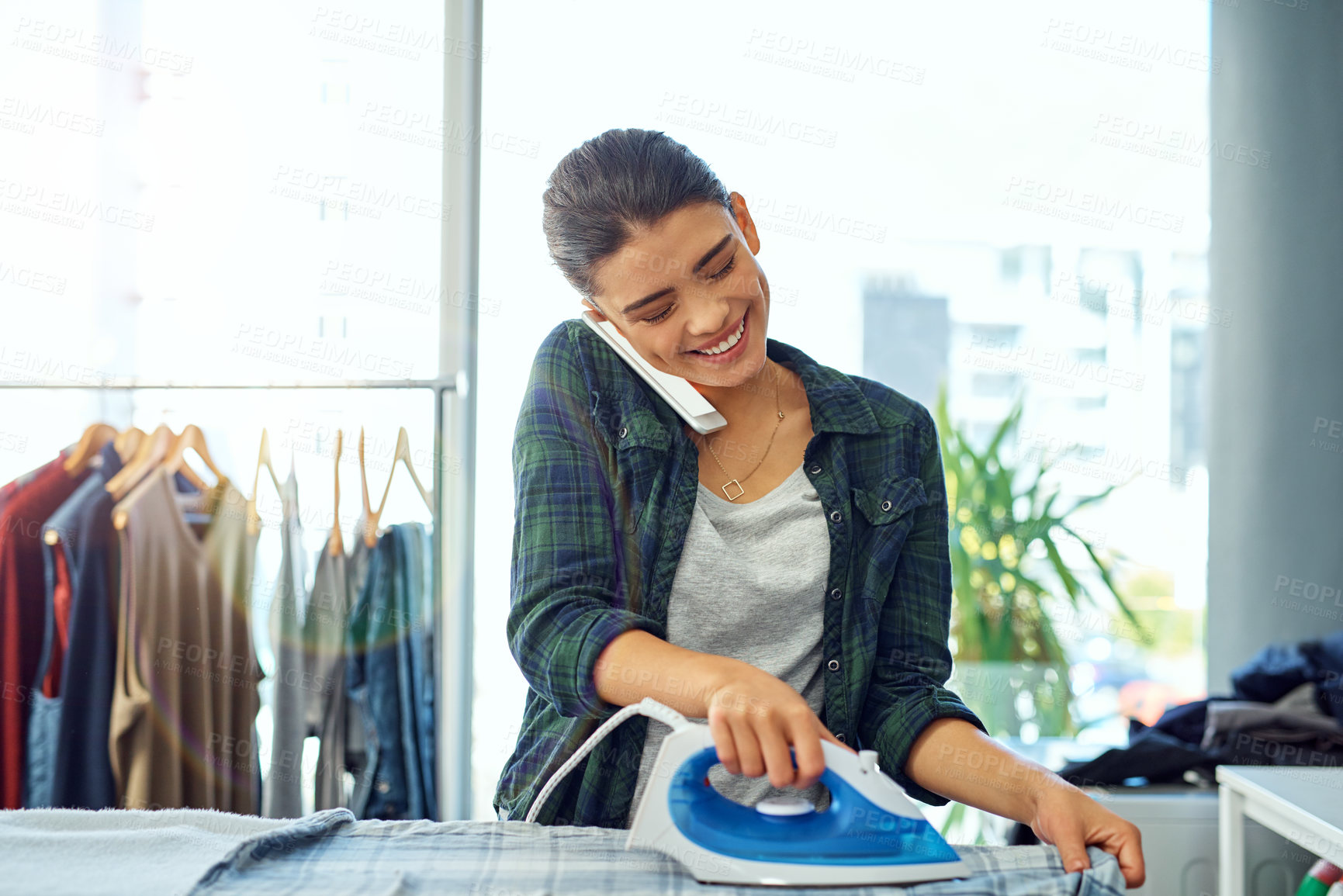 Buy stock photo Laundry, phone call and woman with iron, home and spring cleaning on weekend, linen and smile for routine. Housework, mobile and person with chores, responsibility and happy with conversation