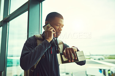 Buy stock photo Shot of a young man checking the time in an airport