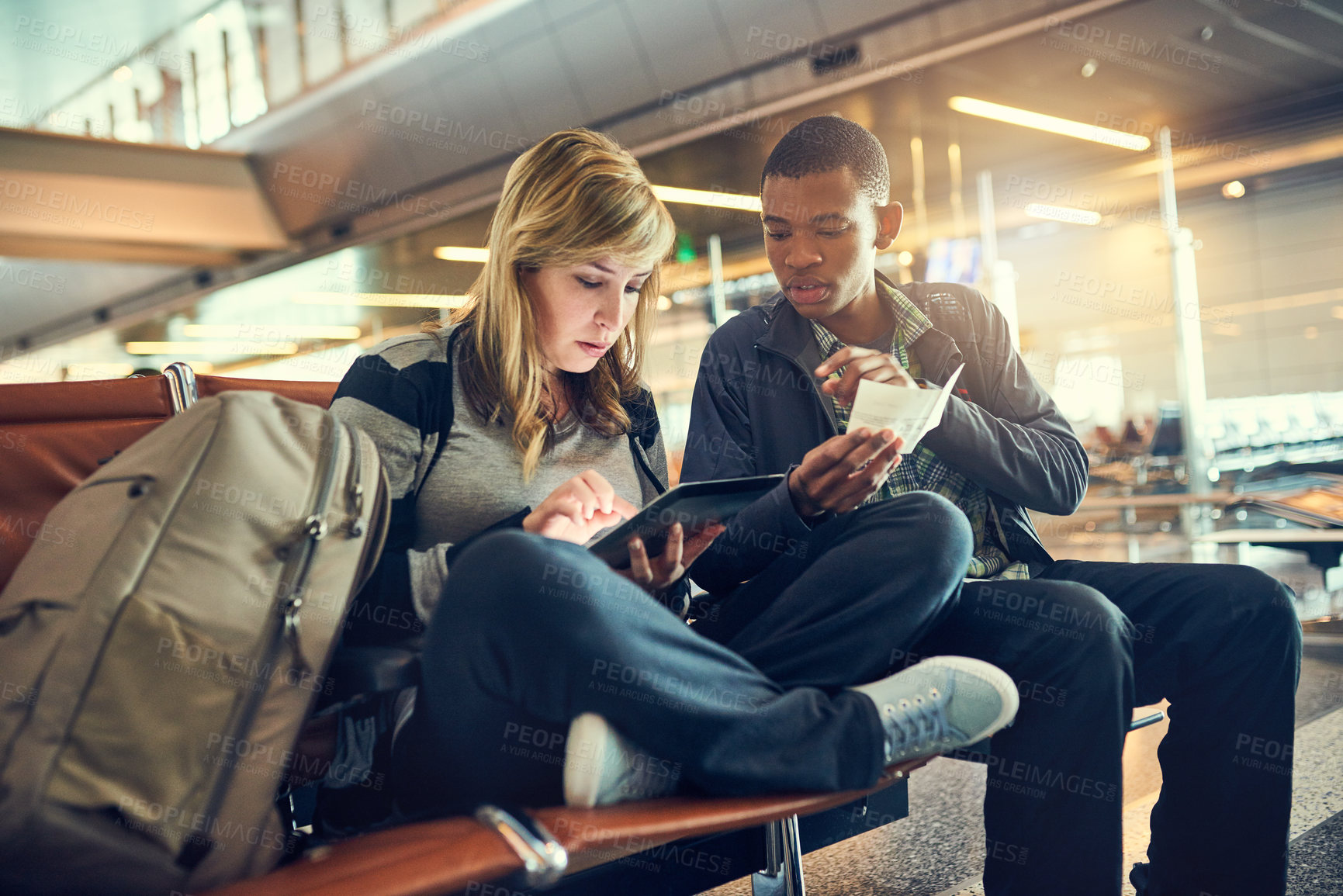 Buy stock photo Interracial, couple and checking on tablet at airport for traveling, trip and ticket. People, man and woman with browsing internet for holiday or vacation on adventure, discover and explore world