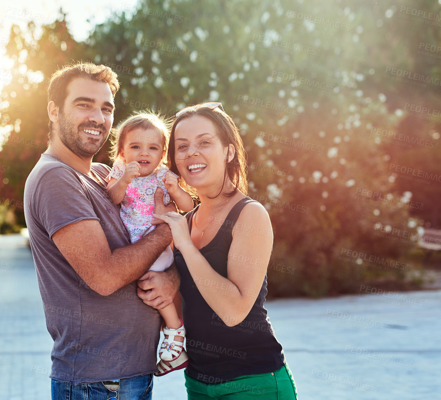 Buy stock photo Happy, portrait and parents with baby in nature for bonding, loving relationship and relax together outdoors. Family, sunshine and mother, father and child for embrace, affection and love on weekend