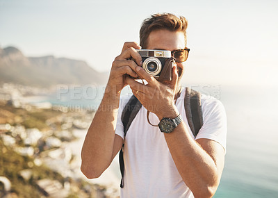 Buy stock photo Cropped portrait of a handsome young man taking photographs while hiking in the mountains