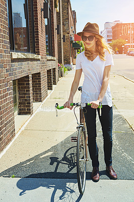 Buy stock photo Shot of a young woman riding a bike in the city