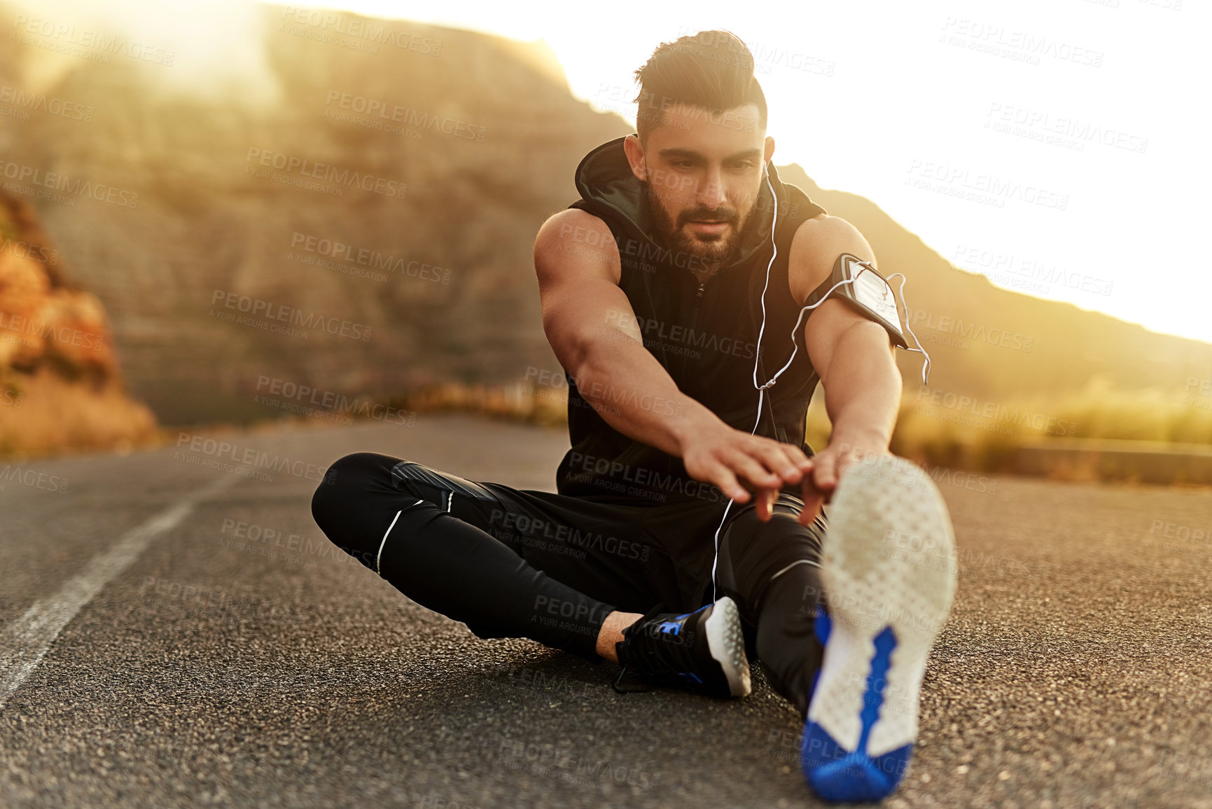 Buy stock photo Man, mountain and headphones with stretching of legs on ground for fitness, workout or training music. Male person, idea and runner in nature with warm up for muscle, preparation or podcast for sport