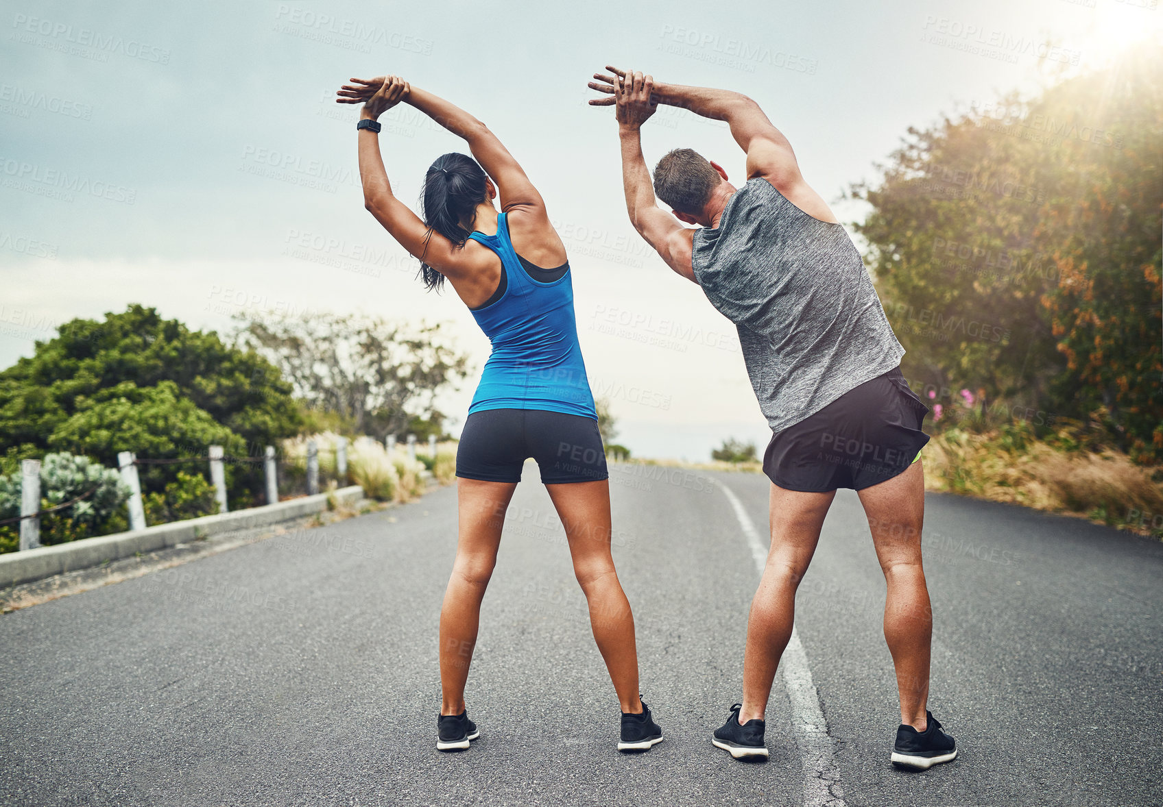 Buy stock photo Runner, training and couple stretching in morning outdoor for benefits to health, wellness and fitness. People, prepare and start of workout with resilience in summer challenge and muscle in back