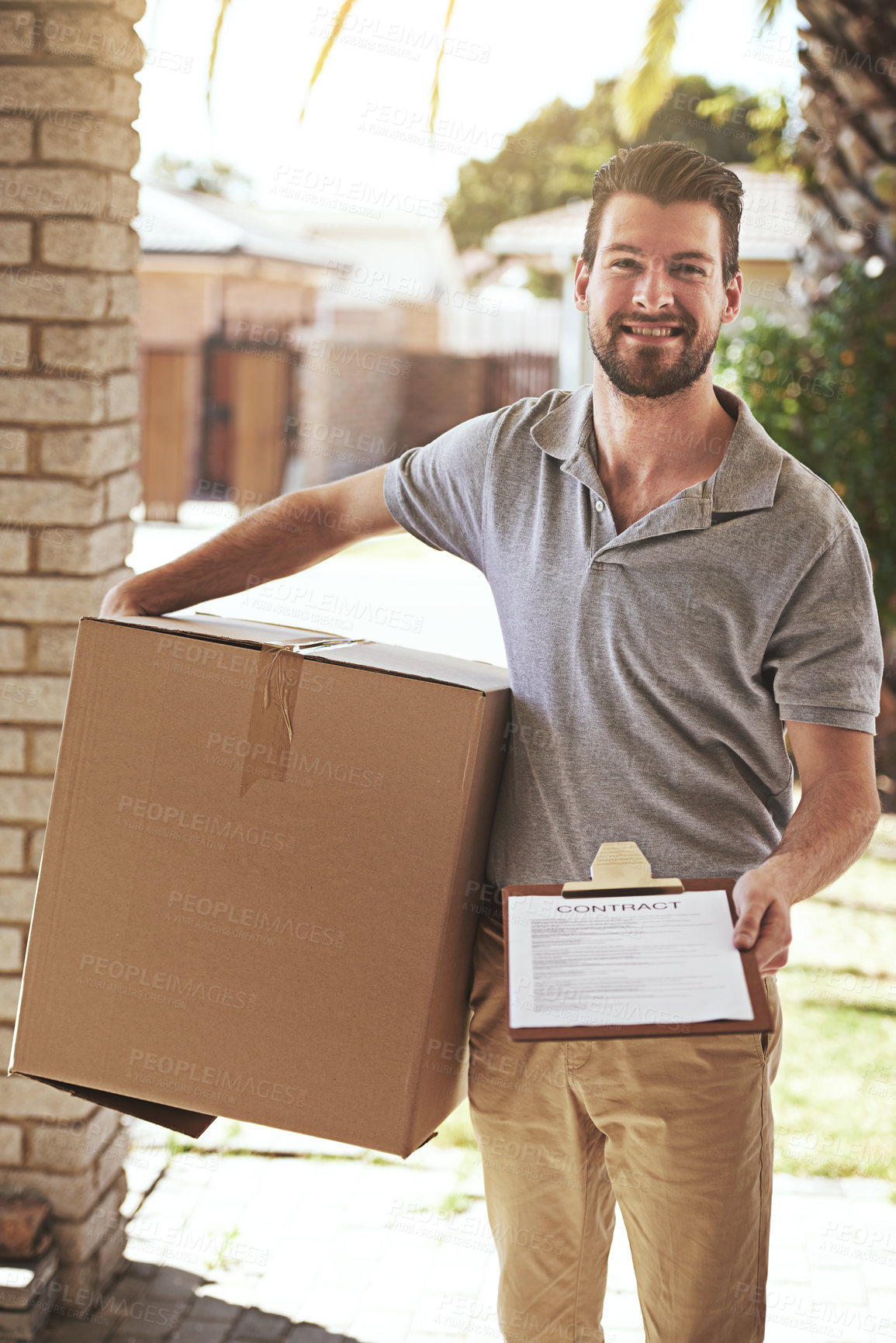 Buy stock photo Shot of a young delivery man making a home delivery