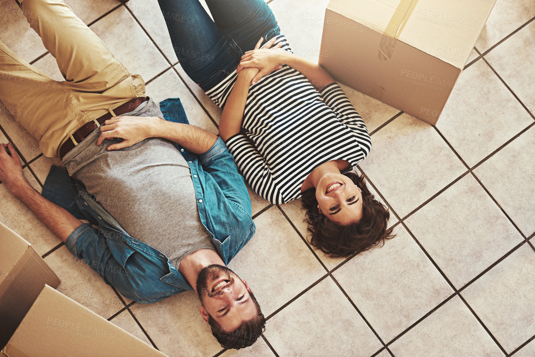 Buy stock photo Shot of a happy young couple relaxing on the floor of their new home