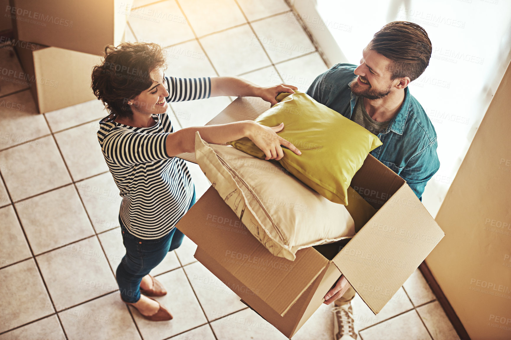 Buy stock photo Shot of a young couple packing up on moving day