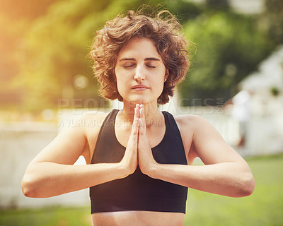 Buy stock photo Shot of an attractive young woman meditating outdoors