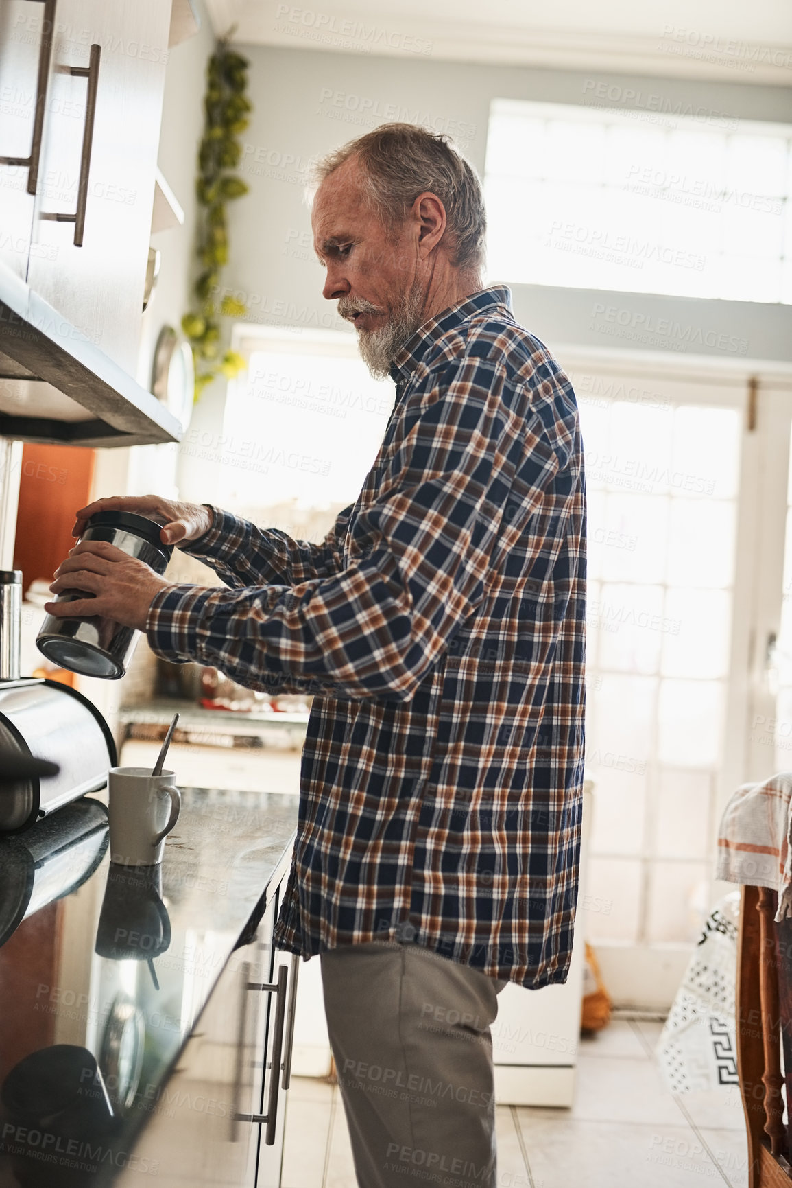 Buy stock photo Morning, senior man and making coffee in kitchen in home for drink, energy or health. Retirement, person and preparing cup of tea, espresso and latte beverage refreshment with jar to relax in house