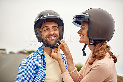 Buy stock photo Cropped shot of a woman adjusting her boyfriend's helmet