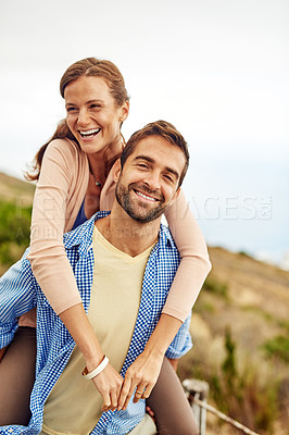 Buy stock photo Cropped shot of a man piggybacking his girlfriend while spending the day outdoors