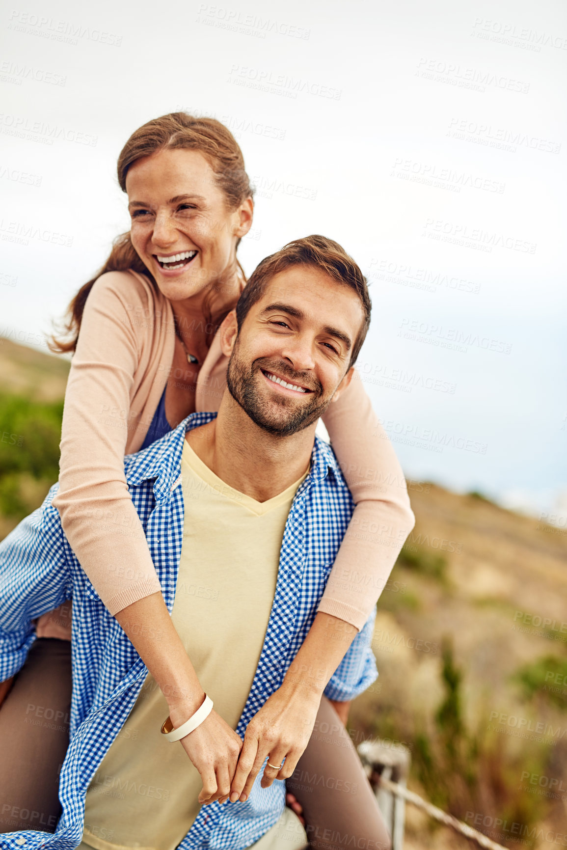 Buy stock photo Cropped shot of a man piggybacking his girlfriend while spending the day outdoors