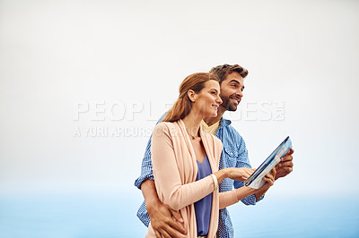 Buy stock photo Cropped shot of an affectionate couple using a map while standing outdoors