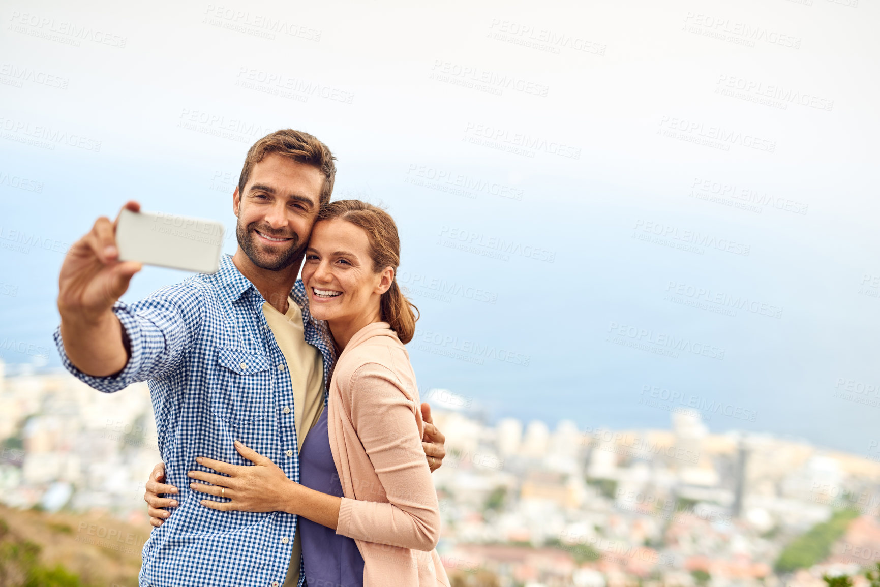 Buy stock photo Cropped shot of an affectionate couple taking selfies outside
