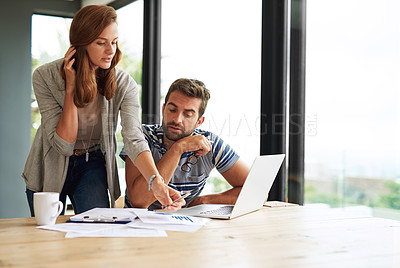 Buy stock photo Cropped shot of a young couple working on their household budget and paying bills online