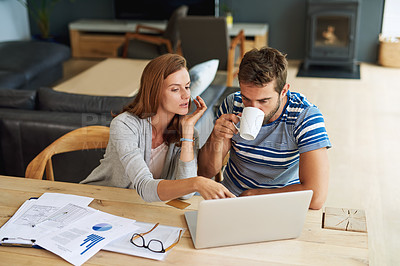 Buy stock photo High angle shot of a young couple working on their household budget and paying bills online