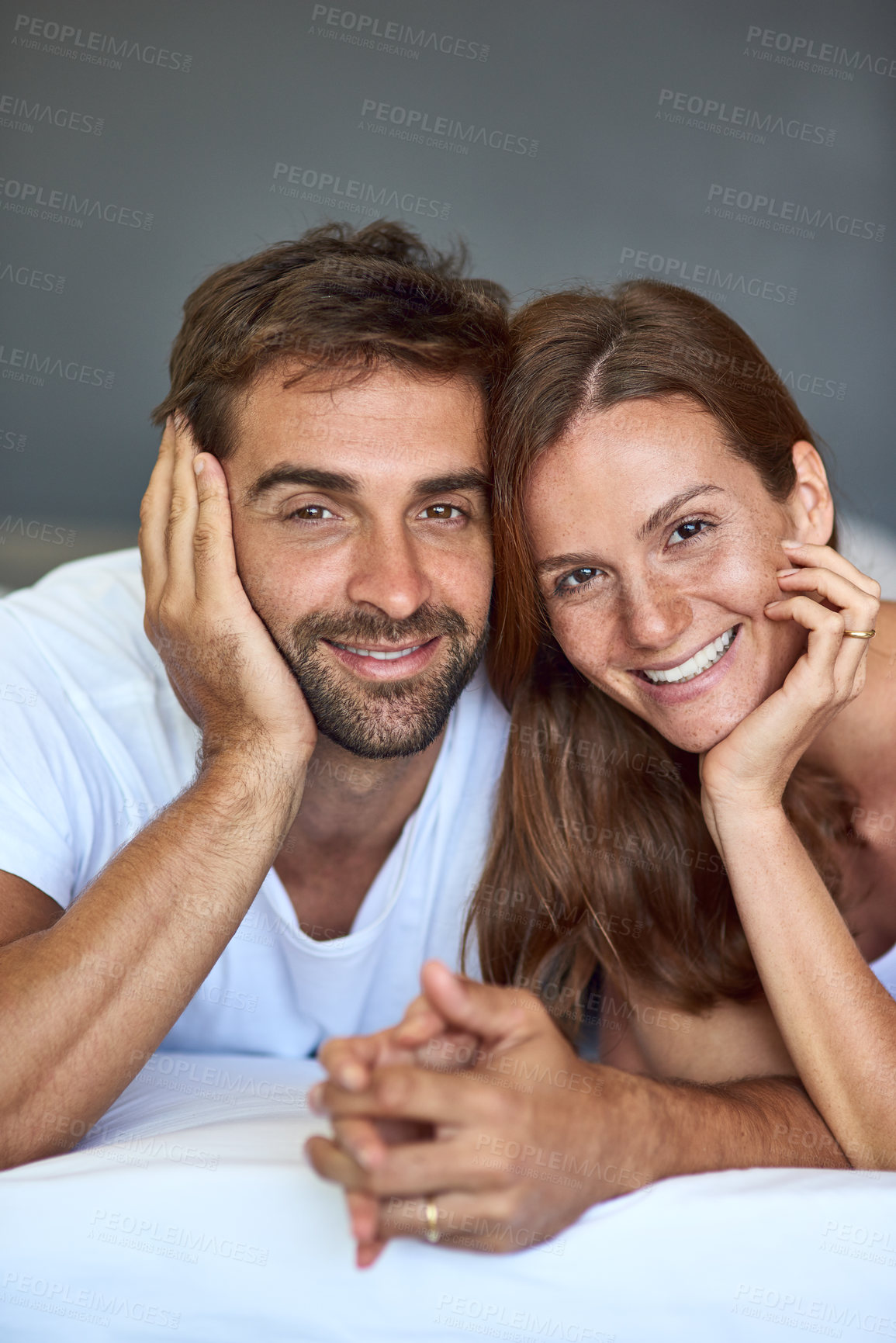 Buy stock photo Happy couple, holding hands or portrait on bed in morning, love or support for marriage commitment at house. Wake up, bonding or people with smile for romantic relationship or anniversary together