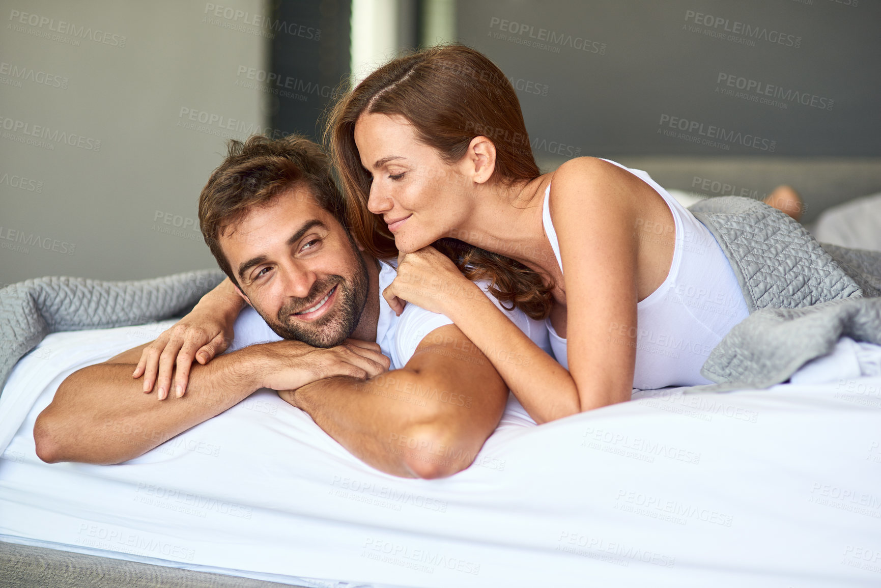 Buy stock photo Happy couple, wake up and resting in bedroom, house or support for marriage commitment in morning. Love, comfort or people bonding with smile for romantic relationship, peace or anniversary together