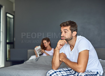 Buy stock photo Shot of a young couple having marital problems in the bedroom at home