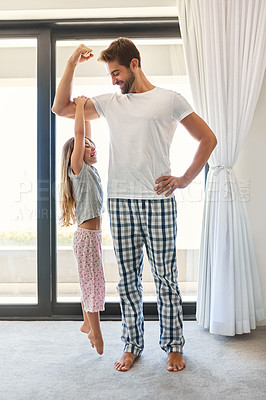 Buy stock photo Full length shot of an adorable little girl hanging from her father's bicep at home