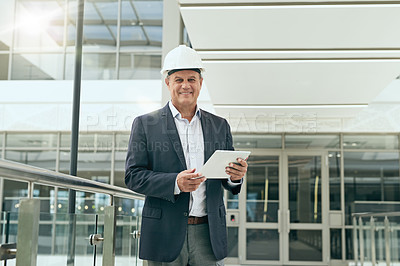 Buy stock photo Portrait of a cheerful professional male architect holding a digital tablet while looking at the camera inside of a building